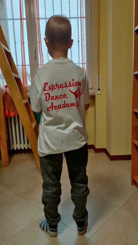 Denis con la maglietta Expression Dance Academy, visto di spalle
